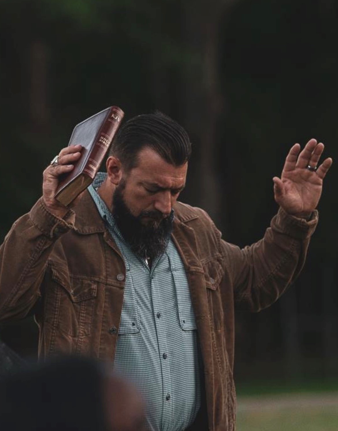 Pastor Joey Castleberry; holding bible with hands to the sky